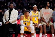 Lakers forward LeBron James, left, sits on the bench next to guard Russell Westbrook, forward Kent Bazemoreand forward Trevor Ariza 