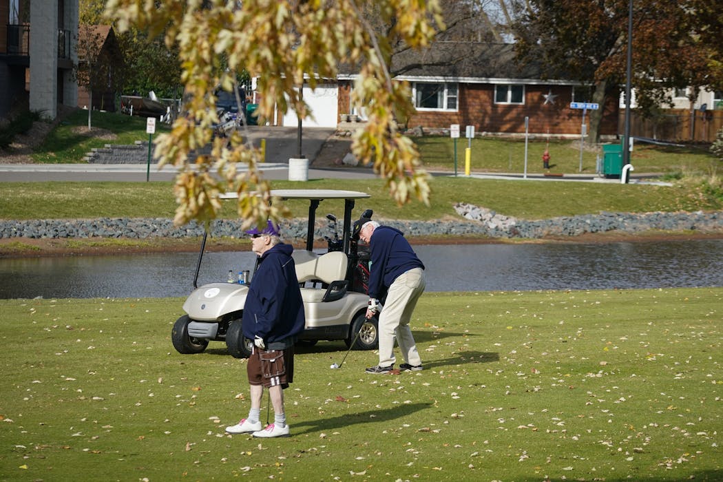 Dale Anderson of Brooklyn Center, left, watched as Tom Kaczmarczyk of Coon Rapids chipped onto the ninth green at New Hope Village Golf Course this month. “We’ll golf until the snow flies,” Anderson said. “We’ve even golfed in a snow storm until we couldn’t see the ball anymore.”