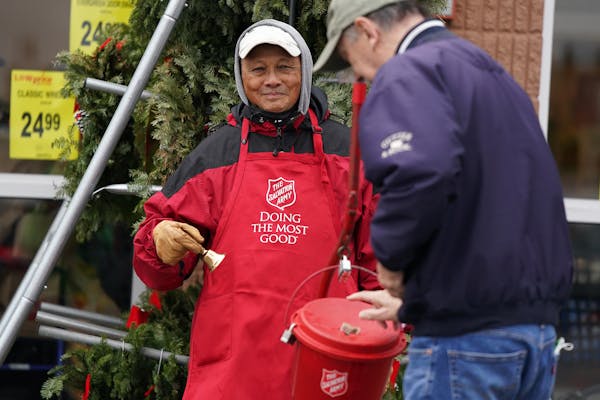 Volunteer Steve Santos of Mendota Heights greets a donor during his first ever shift as a bell-ringer for The Salvation Army Friday, Nov. 12, 2021 at 