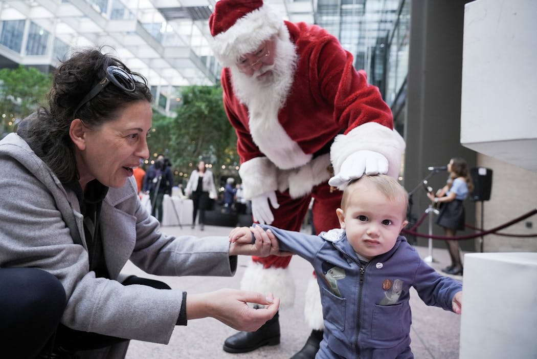 Hamilton Hormann, 13 months, was more interested in the festive lights than Santa Claus, despite his grandmother Oksana Uzun’s best efforts, at the IDS Center’s Crystal Court in Minneapolis on Wednesday.