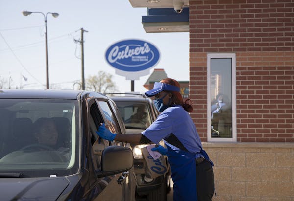 Culver’s employee Teesha Nelson hands a drive-through customer an order outside the restaurant chain’s newest location in Chicago’s Pullman neig