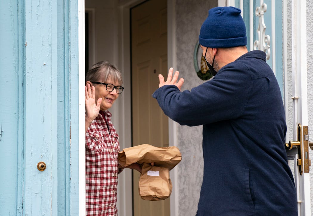 Jacqueline Cable thanks Pete Magnuson outside her home after he delivered her meals as part of the TRUST Meals on Wheels program Thursday in Minneapolis. 
