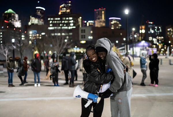Nyagach Kueth, 17, and Markeanna Dionne, 17, hugged Friday as they led a rally outside U.S. Bank Stadium in support of the Prior Lake High School stud