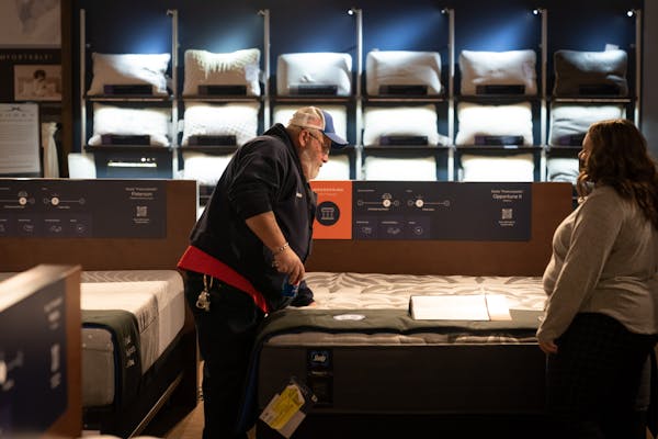 Katie Bergeland, right, a sales associate at the Slumberland Furniture store in Woodbury, helped Dave Thomas of Prescott, Wisc, as he shopped during t