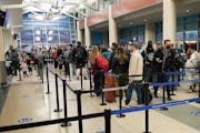 Holiday travelers wait in line to get through TSA security at Terminal 2 of the Minneapolis-St. Paul International Airport on Monday.