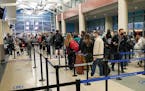 Holiday travelers wait in line to get through TSA security at Terminal 2 of the Minneapolis-St. Paul International Airport on Monday.