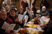 Meg Gronau, of Maplewood (in blue coat) and Ellen Ryan of Minneapolis (in red hat) sang along with more than 75 other people participating Wednesday i