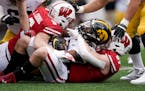 Wisconsin’s linebackers Leo Chenal (5) and Jack Sanborn (57) combined to stop Iowa’s Tyrone Tracy on Oct. 30.