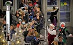 Santa and his elves greet Black Friday shoppers at the Mall of America’s North entrance Friday, Nov. 26, 2021 in Bloomington.