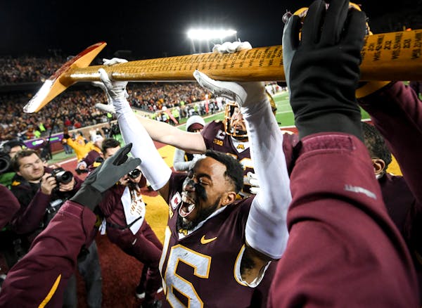 Gophers defensive back Coney Durr takes control of Paul Bunyan’s Axe after the Gophers beat Wisconsin on Saturday.