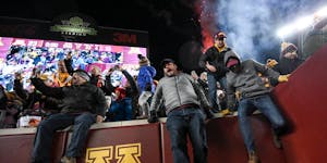 Minnesota fans storm the field after an NCAA football game between the Gophers and the Wisconsin Badgers.