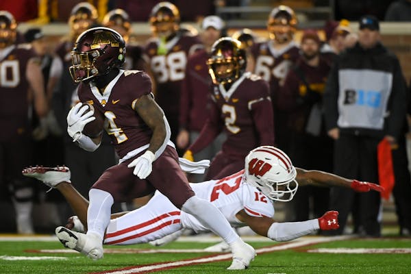 Gophers running back Mar’Keise Irving dodged a tackle by Wisconsin cornerback Max Lofy.
