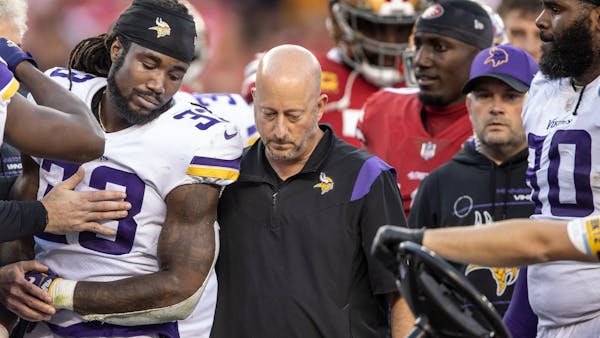 Dalvin Cook leaves the game in the third quarter from a shoulder injury as trainer Eric Sugarman helps him.