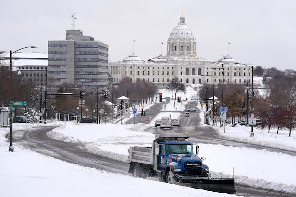 In 2019, a plow truck made its way up the hill in front of the Cathedral of St. Paul, with the Capitol building in the backdrop. 