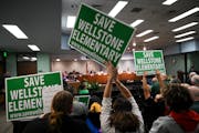 At a November St. Paul school board meeting, Wellstone Elementary supporters held signs to save the school. Wednesday’s vote approved a district con