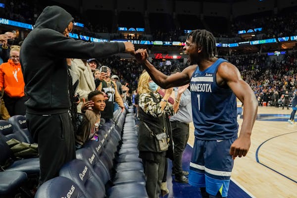 Timberwolves guard Anthony Edwards celebrated with a fan after defeating Miami 121-120 in two overtimes on Nov. 27.