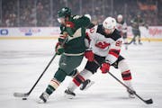 Minnesota Wild right wing Ryan Hartman tried to get control of the puck in the first period while shadowed by New Jersey Devils left wing Tomas Tatar 