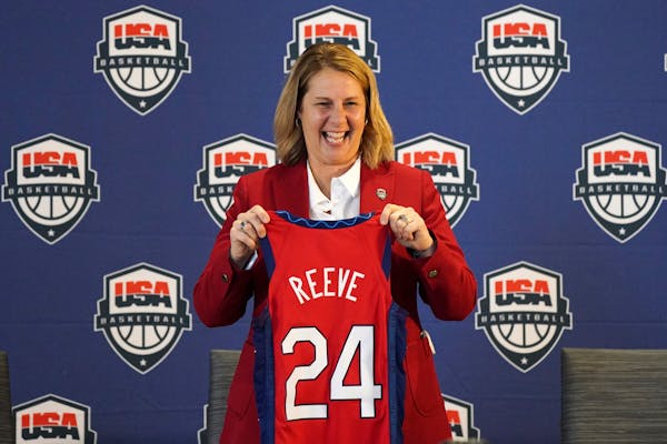 Minnesota Lynx head coach Cheryl Reeve poses with her ceremonial jersey during a press conference to announce she'd been named the head coach of women