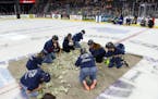 Teachers scramble for dollar bills to fund projects for their classrooms on Dec. 11 between periods at the Sioux Falls Stampede game in Sioux Falls, S