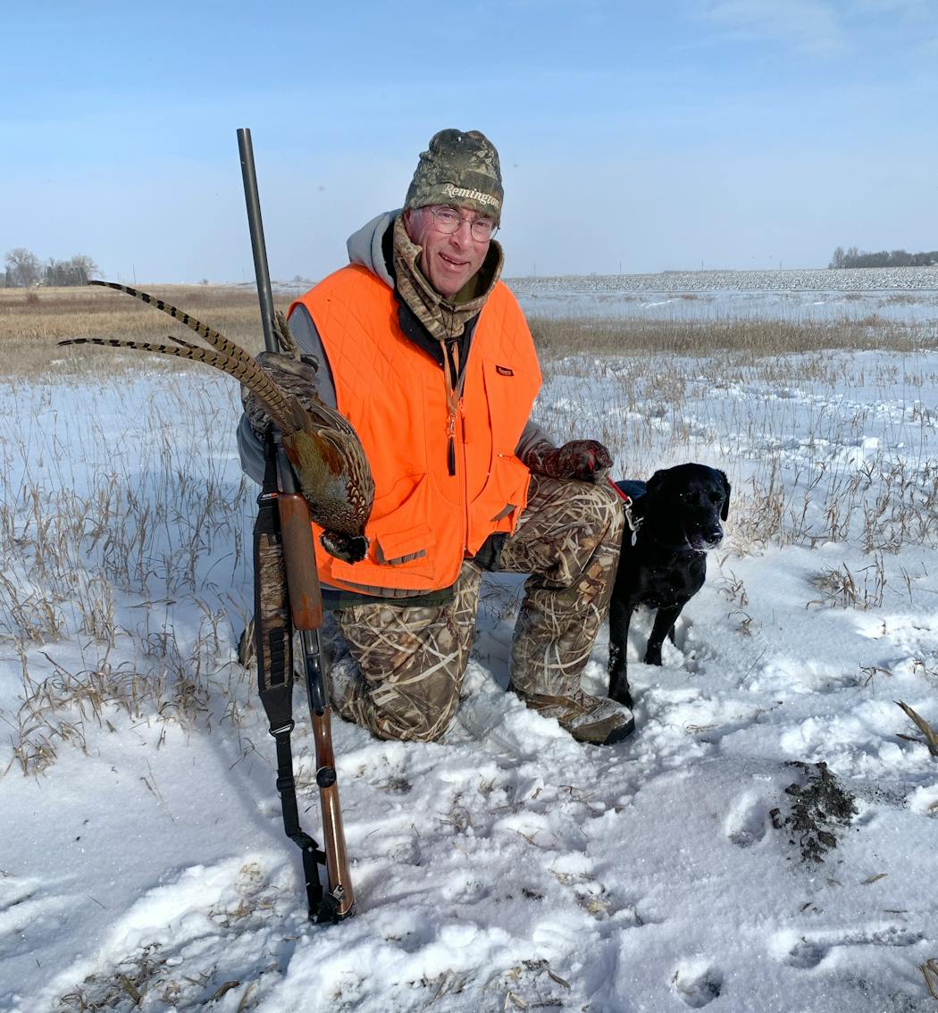 Dan Gahlon of Dellwood with Tide, his black Labrador retriever, and a hard-won December rooster.
