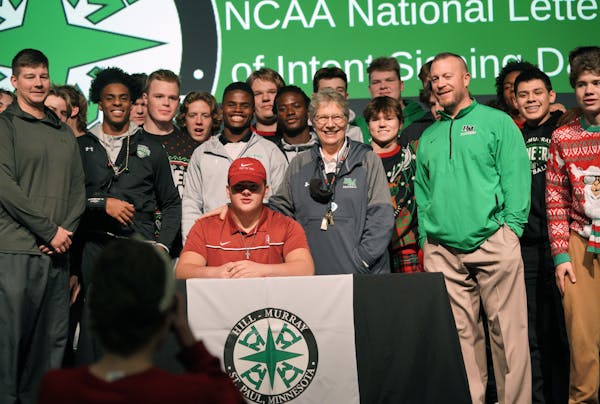 Surrounded by teammates, coaches and campus minister Sister Linda Soler, offensive lineman Lucas Heyer,  the top recruit among football players in the