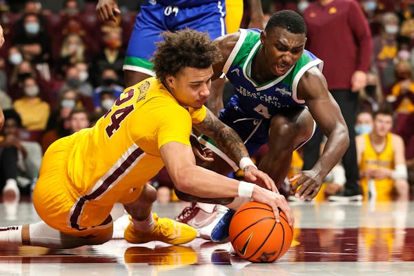 Minnesota guard Sean Sutherlin (24) and Texas A&M Corpus Christi guard Jalen Jackson (4) compete for the ball during the second half of an NCAA colleg