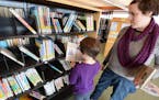 Eagan residents Nola McMahon, 7, and her mom, Jessica McMahon, found some books at the Wescott Library in Eagan in 2013.