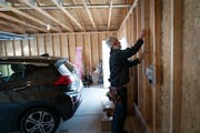 Electrician Adam Wortman of St. Paul-based Ray of Light Electric installs a 240-volt, Level 2 charger in the Alex Shaver’s and Megan Mekoli’s sout