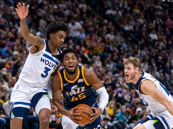 Jazz guard Donovan Mitchell cut between Wolves forwards Jaden McDaniels (3) and Jake Layman, on his way to 28 points, seven assists and five rebounds 