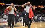NBA officials Tyler Ford, left, and Matt Myers pulled on masks when leaving the court after an NBA game in Orlando. COVID protocols differ across spor