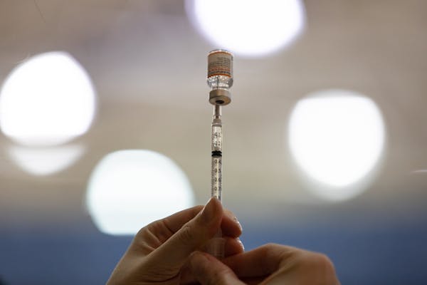 A health care worker prepared a COVID-19 vaccine in Southfield, Mich., in November.
