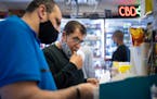 Khaled Aloul, owner of Oxboro Market, with manager and son-in-law Mike Alhataba, left, working in the store in April in Bloomington.