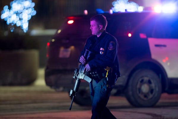 A police officer carrying a rifle exits the Mall of America following a shooting, Friday, Dec. 31, 2021, in Minneapolis, Two people were shot and woun