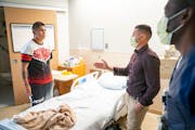 Luis Stalin Sumba listened as Nick Hetchler interpreted for nurse Amir Hassan before Sumba was discharged at Hennepin Healthcare last week.