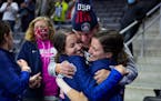 Edina natives Tabitha Peterson, left, and Tara Peterson, right, hugged their father, Sheldon Peterson, after winning the U.S. Olympic Curling Team Tri