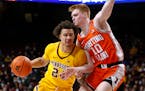 Minnesota guard Sean Sutherlin (24) tries to move around Illinois guard Luke Goode (10) during the first half of a game Tuesday.