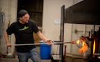 Hennepin Handmade’s Derek Hostetler works on a piece in the hot shop at the Glass House building.