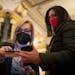 Gail Nelson with the Hennepin Theatre Trust, left, checked the ID of Dorothy Hamman after seeing her vaccination status in an app on her phone in the 
