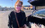 Hairdresser Chelsea Woody stands outside her car at a grocery store Tuesday in Charleston, West Virginia. Woody, a single mother, relied on a monthly 