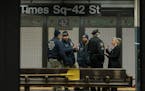 Police officers on a subway platform after a woman was stuck by a train at Times Square subway station in New York, Jan. 15, 2022.