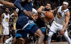 Wolves center Karl Anthony-Towns fought for the ball as Warriors defenders closed in during the second quarter at Target Center on Sunday.