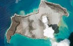 In this satellite photo taken by Planet Labs PBC, an island created by the underwater Hunga Tonga Hunga Ha’apai volcano is seen smoking Jan. 7, 2022