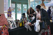 Oluwatobi Oluwagbemi, right, stopped by the Batacali Fashion Design booth owned by Rosa Mensah, center, at the MLK Now 2020 event on Saturday, Jan. 15