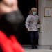 A woman wearing a face mask to curb the spread of coronavirus, exits from a Greek Orthodox church in Athens, Greece, Monday, Jan. 17, 2022. 