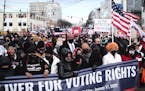 Martin Luther King III, fourth from right, helps lead a march in Washington on Martin Luther King Jr. Day, Monday, urging lawmakers to take action on 