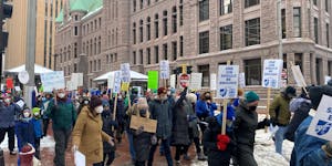 Hundreds of educators and families marched through downtown Minneapolis on Monday in support of higher wages for educational support professionals wor