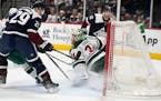 Nathan MacKinnon, left, scores a third-period goal that Wild coach Dean Evason argued never went into the net.