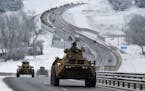 A convoy of Russian armored vehicles moves along a highway in Crimea, Tuesday, Jan. 18, 2022. 