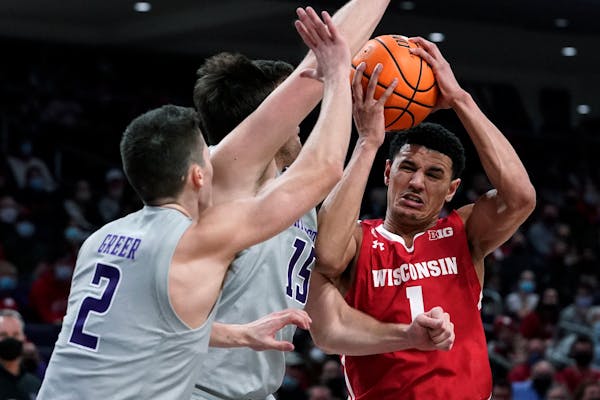 Wisconsin guard Johnny Davis drives to the basket against Northwestern guard Ryan Greer and center Ryan Young during the first half 
