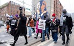 People marched down Auburn Avenue and past a mural of Rep. John Lewis during the Martin Luther King Jr. Day march Monday, Jan. 17, 2022 in Atlanta.